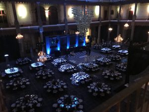 Vista del salón de una boda desde arriba, con las mesas iluminadas y la pista al centro