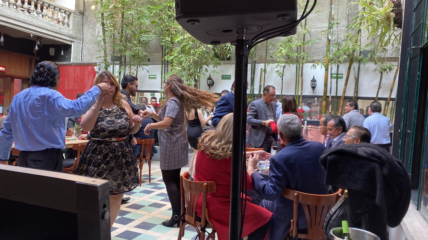 Invitados bailando en un patio con bambú durante un evento de día, con bafle profesional de Echoe Entertainment